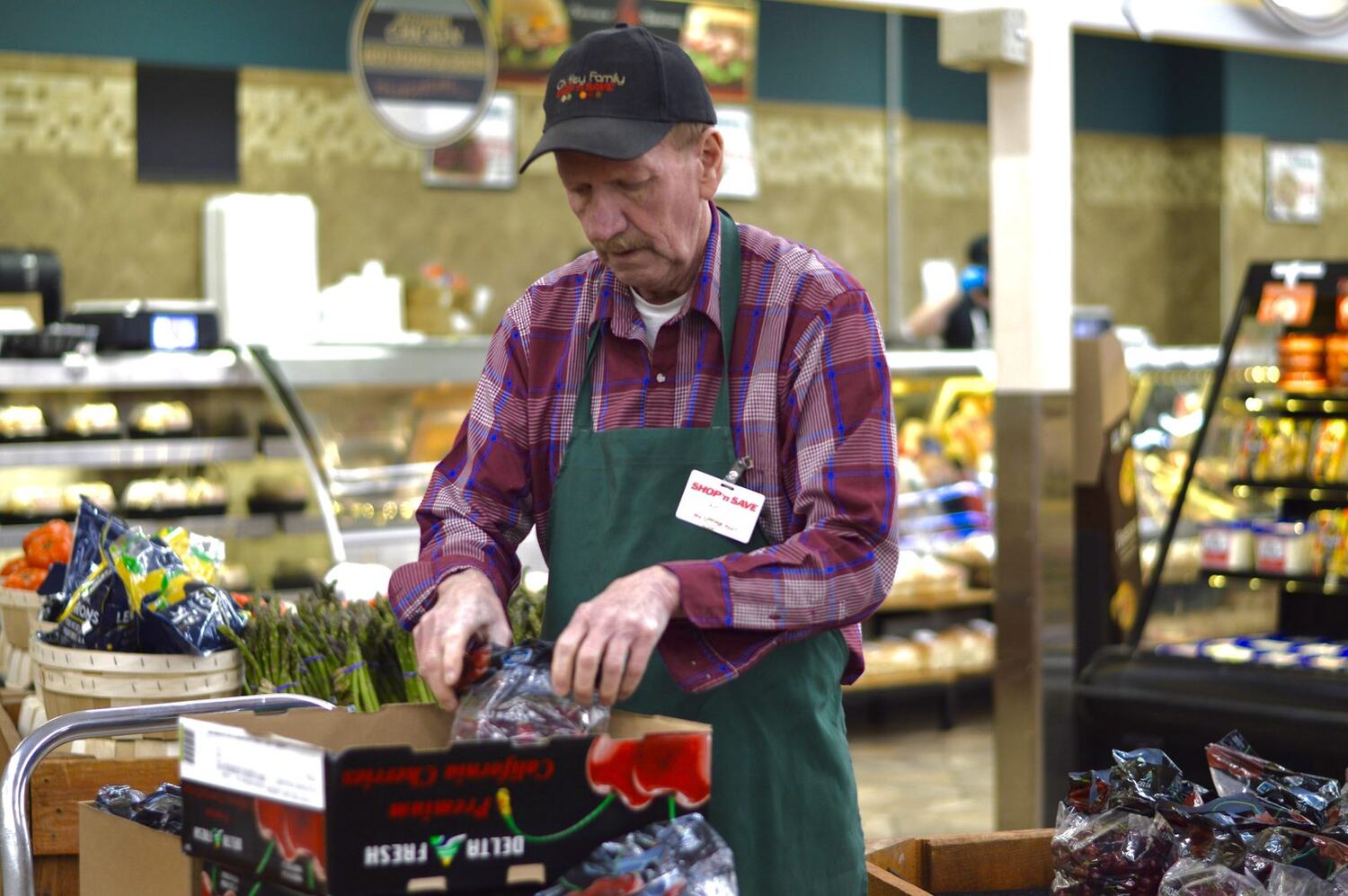 A deli associate stocking the fresh case