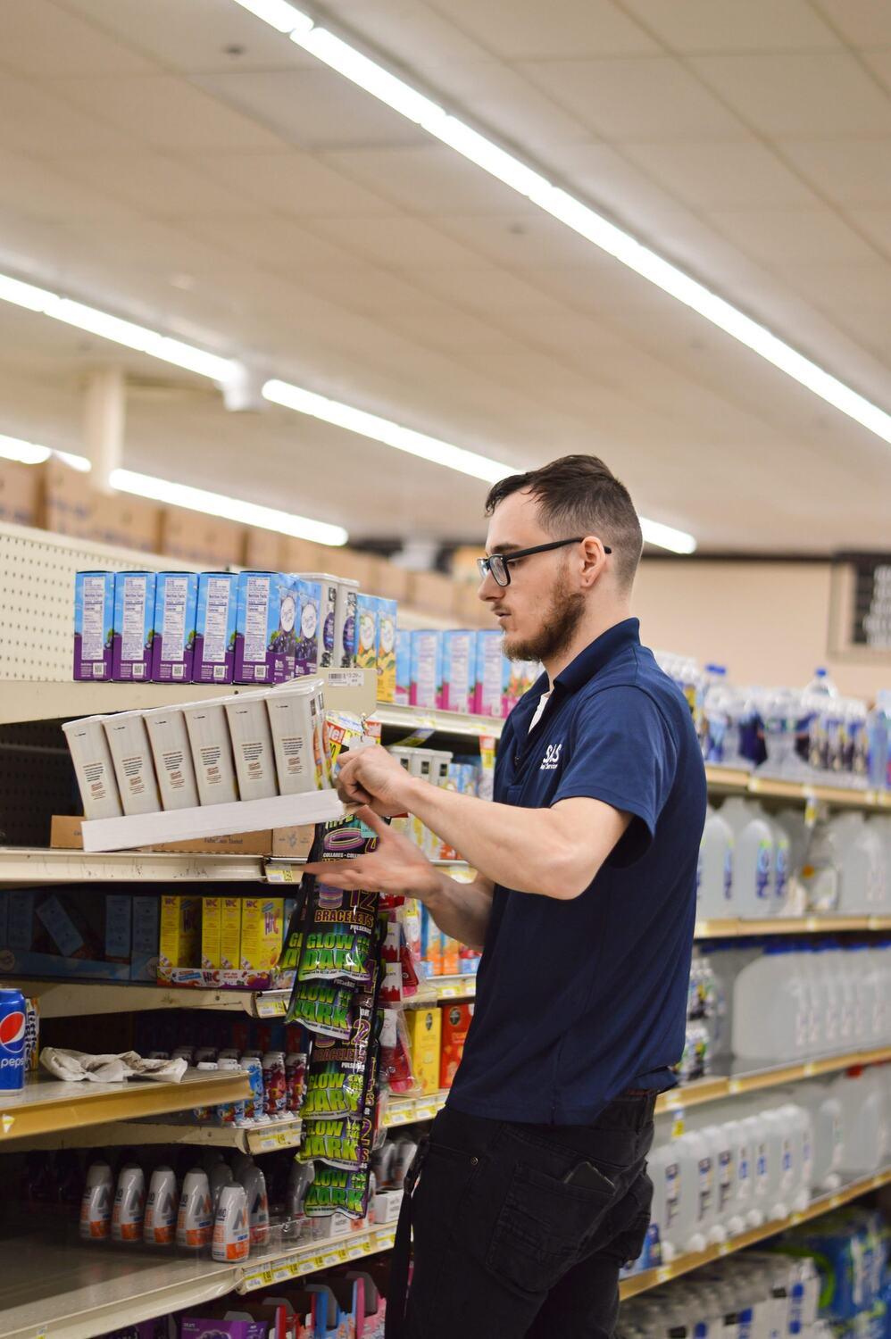 Grocery associate building a beverage display